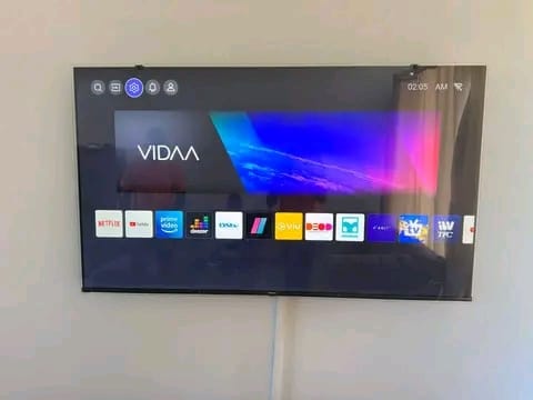 Wall-mounted Ultra HD smart TV showing a vivid landscape image