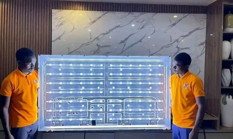 Bluetech TV Repairs technicians testing a TV LED backlight strip assembly lit up on the bench